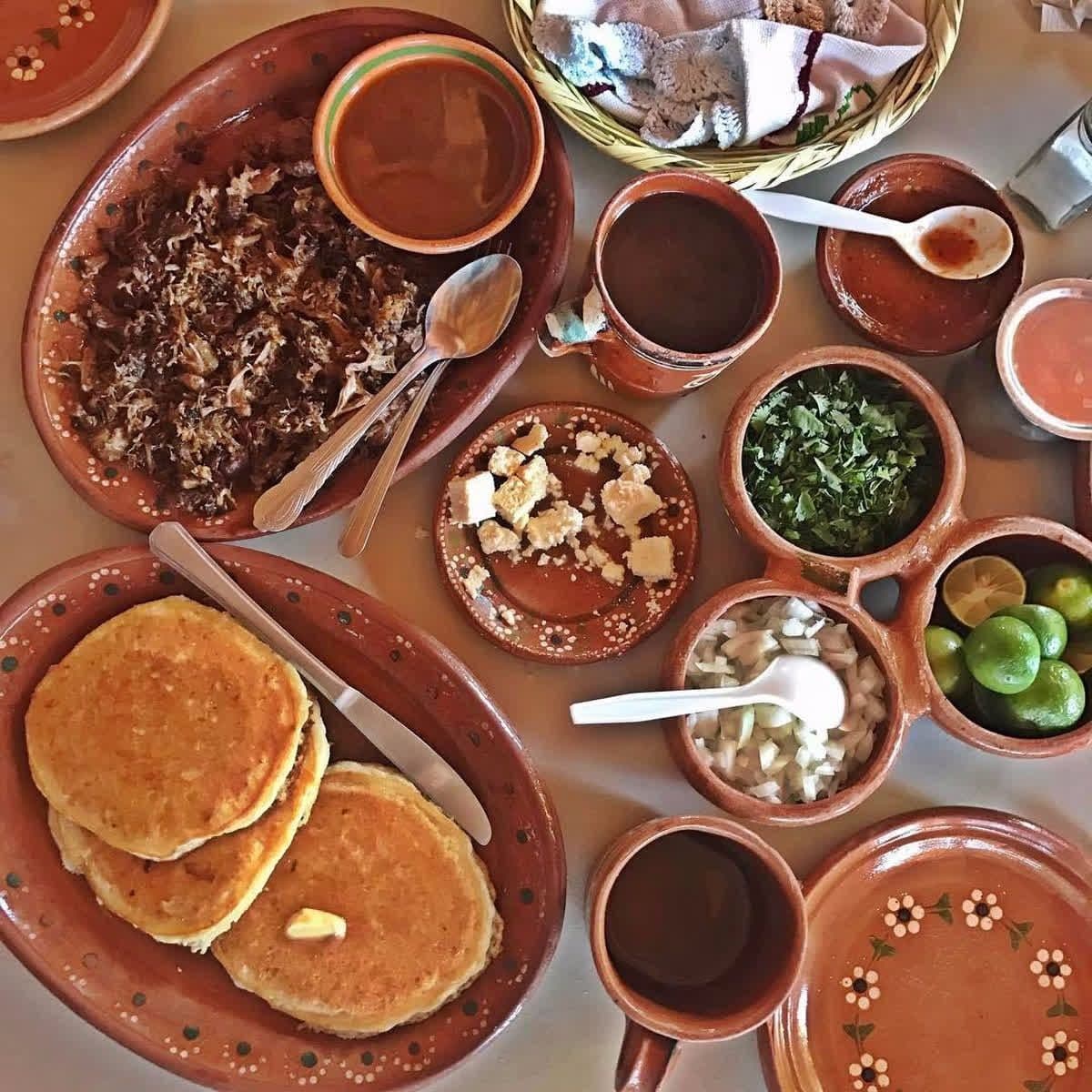 Mexican breakfast with pancakes, coffee, and clay dishes at La Cocina de Doña Esthela.